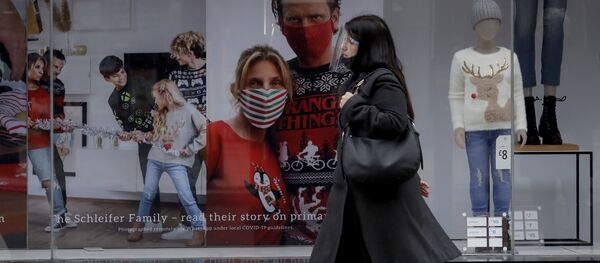 A woman wearing a face shield walks past the front window of the Primark clothing store on Oxford Street during England's second coronavirus lockdown, in London, Monday, Nov. 23, 2020 - 俄罗斯卫星通讯社