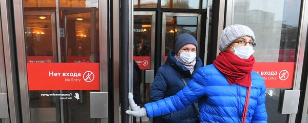 евушки в защитных масках выходят с одной из станций Московского метрополитена.   - 俄羅斯衛星通訊社