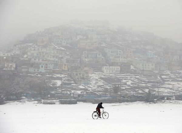 Велосипедист во время снегопада на фоне заснеженного Кабула, Афганистан - 俄羅斯衛星通訊社