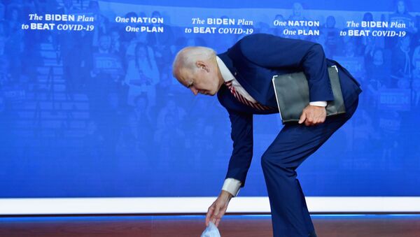 Кандидат в президенты США Джо Байден наклоняется за упавшей медицинской маской - 俄罗斯卫星通讯社