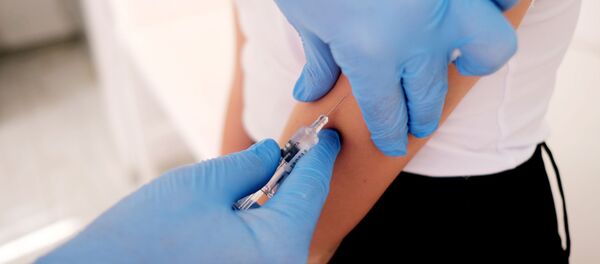 Медик делает прививку от гриппа.  - 俄罗斯卫星通讯社