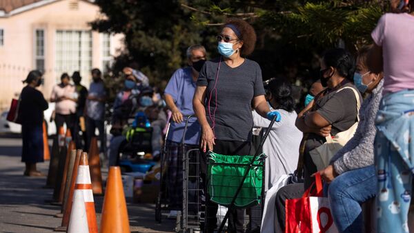 People wait in line as the Los Angeles Regional Food Bank distributes food outside a church during the outbreak of the coronavirus disease (COVID-19) in Los Angeles, California, U.S., November 19, 2020.  - 俄罗斯卫星通讯社