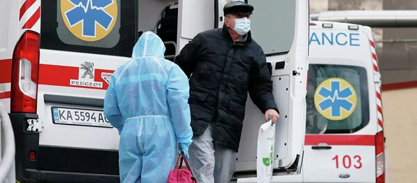 Медик и пациент у автомобиля скорой помощи в Киеве Медик и пациент у автомобиля скорой помощи в Киеве - 俄罗斯卫星通讯社