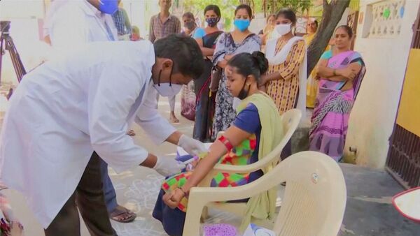 Healthcare personnel takes a blood sample from a patient during an examination, after hundreds of people were hospitalised due to an unknown illness in the southern state of Andhra Pradesh, in this still frame taken from video dated December 9, 2020 - 俄罗斯卫星通讯社