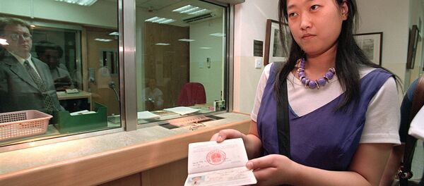 Девушка держит загранпаспорт. Гонконг - 俄罗斯卫星通讯社