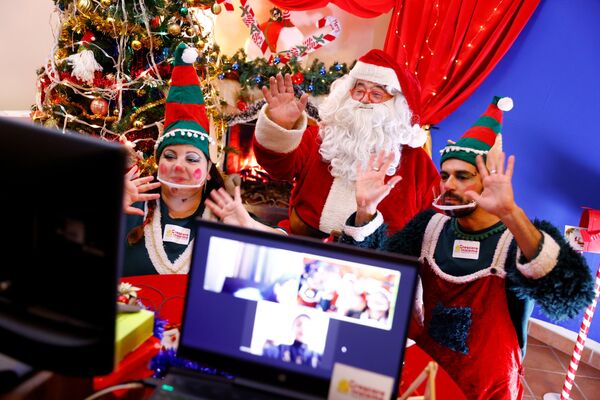 穿着圣诞老人服装的小伙子和他穿着精灵服装的助手在意大利罗马通过Zoom平台与孩子们聊天 - 俄罗斯卫星通讯社