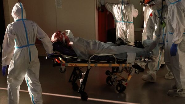 Медицинские работники транспортируют пациента во временном госпитале для больных COVID-19, организованном в выставочном комплексе Ленэкспо. - 俄罗斯卫星通讯社