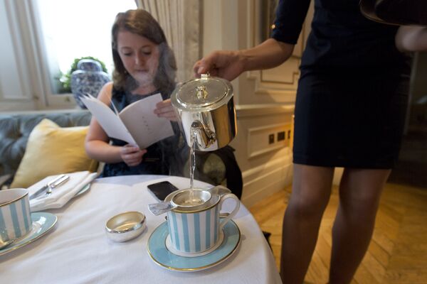 肯辛顿酒店工作人员为一名女士倒茶，英国伦敦 - 俄罗斯卫星通讯社