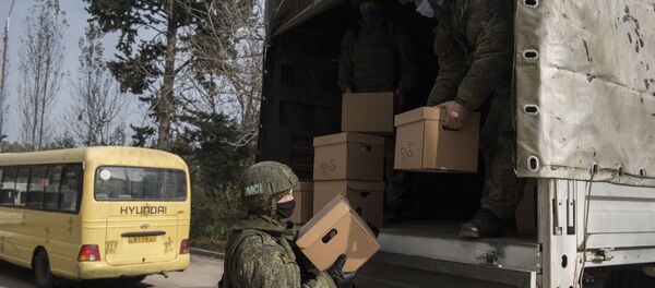 Военнослужащие российского Центра по примирению враждующих сторон выгружают коробки с гуманитарной помощью в городеа Мартакерт в Нагорном Карабахе - 俄罗斯卫星通讯社