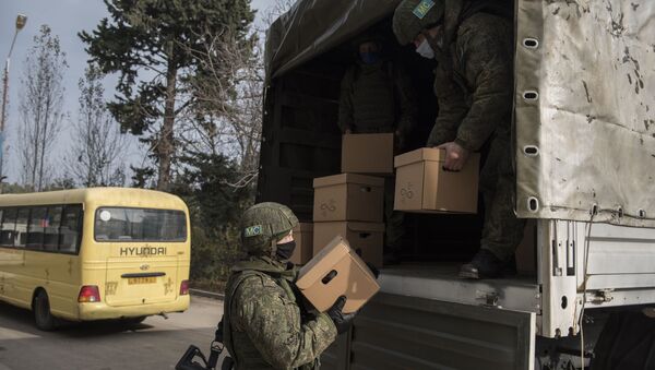 Военнослужащие российского Центра по примирению враждующих сторон выгружают коробки с гуманитарной помощью в городеа Мартакерт в Нагорном Карабахе - 俄羅斯衛星通訊社