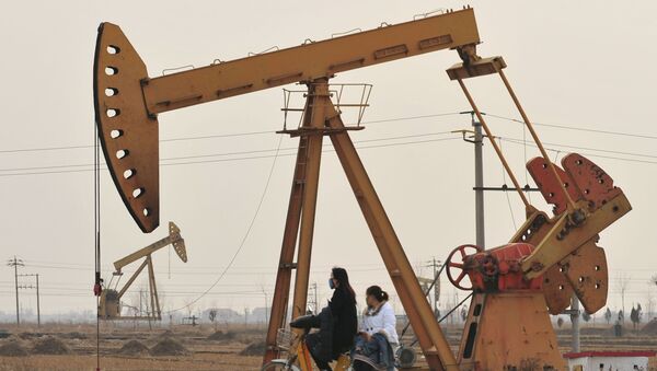 Люди на скутере на фоне нефтяных вышек в Цанчжоу  - 俄羅斯衛星通訊社