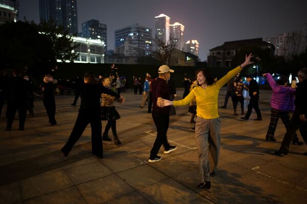 Люди танцуют ночью парке спустя год после вспышки COVID-19 в Ухане - 俄羅斯衛星通訊社