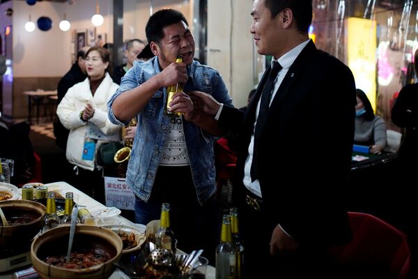 Мужчина открывает пиво зубами в одном из ресторанов Уханя - 俄罗斯卫星通讯社