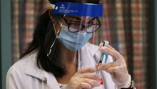 Медицинский работник во время вакцинации от коронавируса. Нью-Йорк. - 俄羅斯衛星通訊社