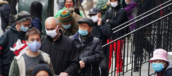 People wait in line at the St. Clements Food Pantry for food during the coronavirus disease (COVID-19) pandemic in the Manhattan borough of New York City, New York, U.S., December 11, 2020. - 俄羅斯衛星通訊社