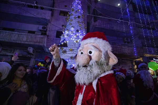 Мужчина в костюме Санта-Клауса во время празднования Рождества в сирийском городе Эль-Камышлы - 俄罗斯卫星通讯社