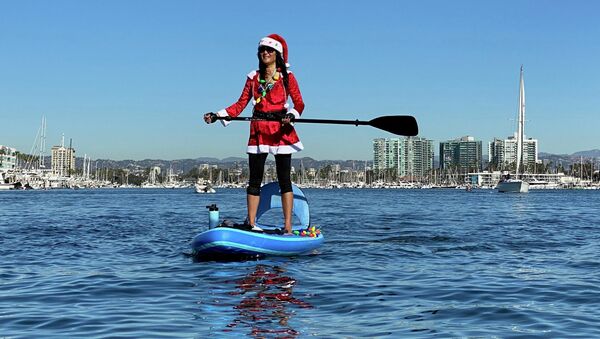 Девушка в костюме Санта-Клауса на SUP-серфе в Лос-Анджелесе, Калифорния - 俄罗斯卫星通讯社