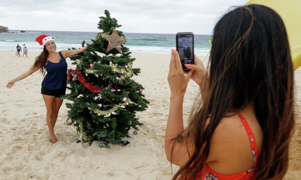 Девушки фотографируются у рождественской ели на пляже в Сиднее, Австралия  - 俄罗斯卫星通讯社