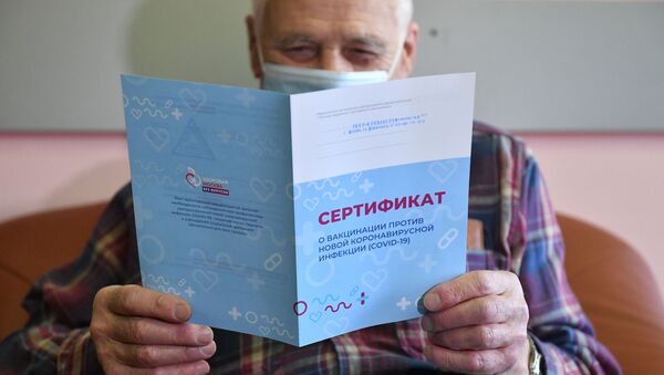 Мужчина держит в руках сертификат о вакцинации против коронавирусной инфекции (COVID-19). - 俄羅斯衛星通訊社