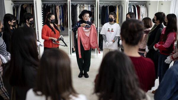Дизайнер демонстрирует одежду ученикам в Liucundao Business School. Пекин - 俄羅斯衛星通訊社