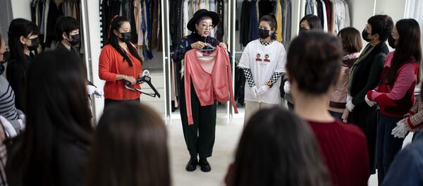 Дизайнер демонстрирует одежду ученикам в Liucundao Business School. Пекин - 俄罗斯卫星通讯社
