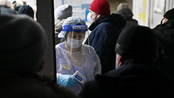 Измерение температуры людям при входе в поликлинике городской больницы №2 в Омске.  - 俄羅斯衛星通訊社