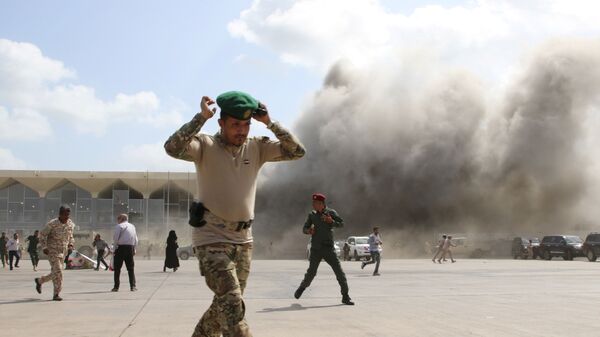 A security personnel member reacts as dust rises after explosions hit Aden airport, upon the arrival of the newly-formed Yemeni government in Aden, Yemen December 30, 2020. - 俄羅斯衛星通訊社