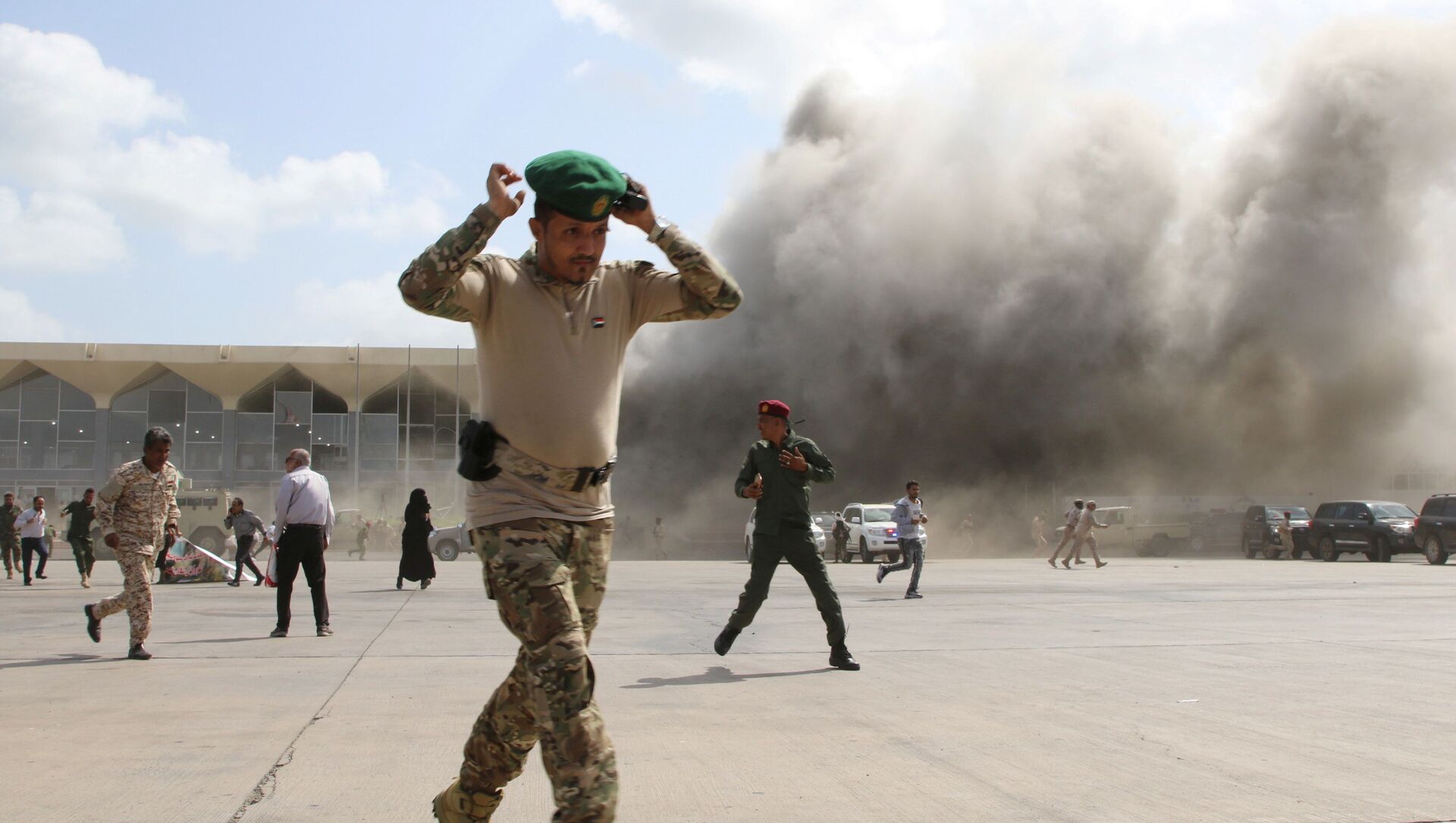 A security personnel member reacts as dust rises after explosions hit Aden airport, upon the arrival of the newly-formed Yemeni government in Aden, Yemen December 30, 2020. - 俄罗斯卫星通讯社, 1920, 13.06.2021
