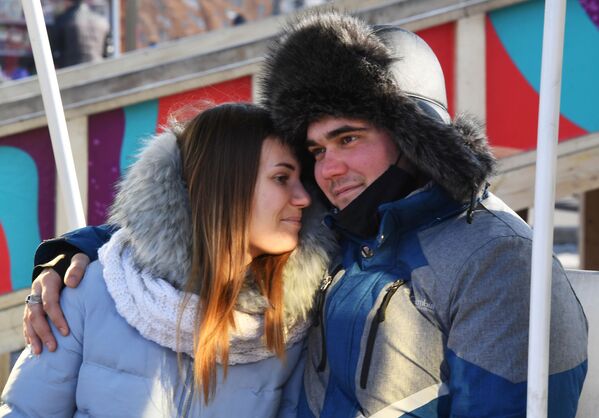 乌苏里斯克中央广场，一对情侣在冰雪小镇里荡秋千 - 俄罗斯卫星通讯社