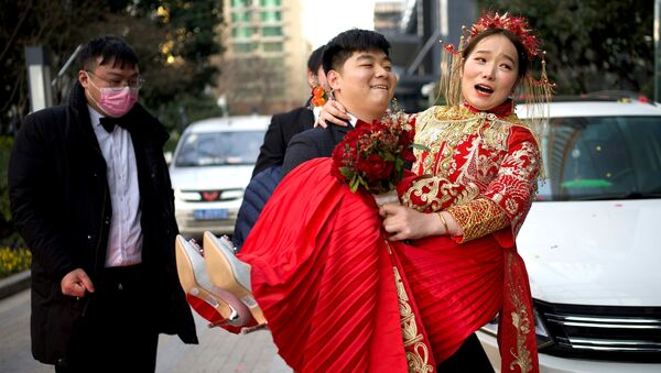 Жених несет невесту в отель после их новогодней свадьбы в Ухане, Китай - 俄罗斯卫星通讯社