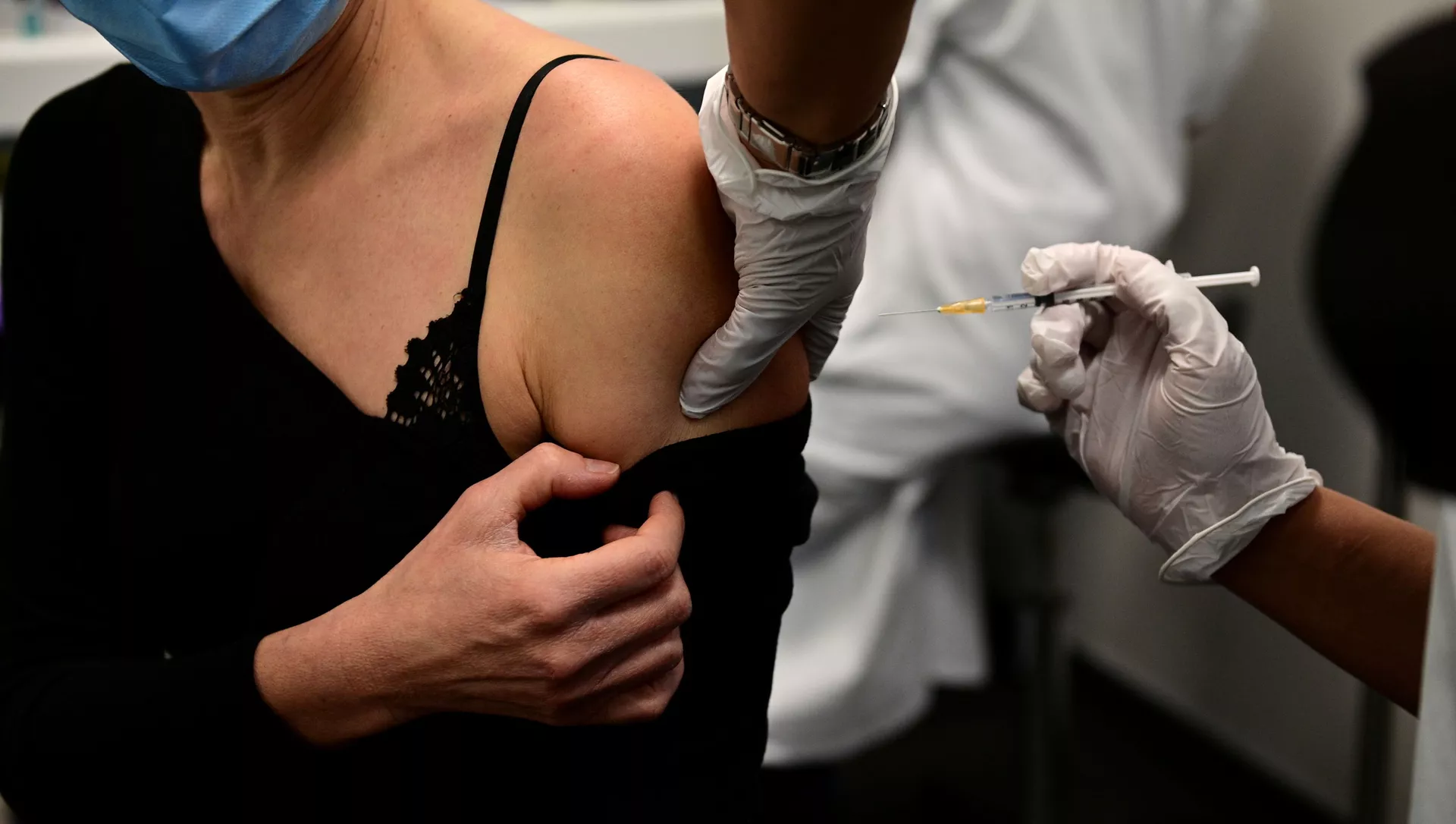 Женщина получает вакцину от COVID-19 во время кампании вакцинации медицинских работников в центре вакцинации в Париже