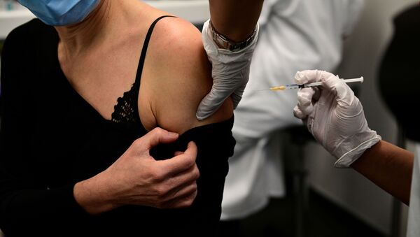 Женщина получает вакцину от COVID-19 во время кампании вакцинации медицинских работников в центре вакцинации в Париже - 俄罗斯卫星通讯社