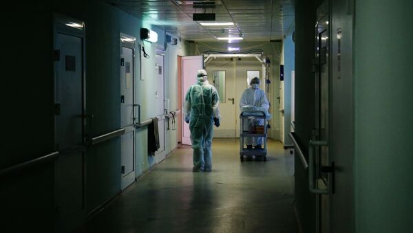 Медики в защитном противоэпидемическом костюме в коридоре Новосибирской областной клинической больницы. - 俄羅斯衛星通訊社