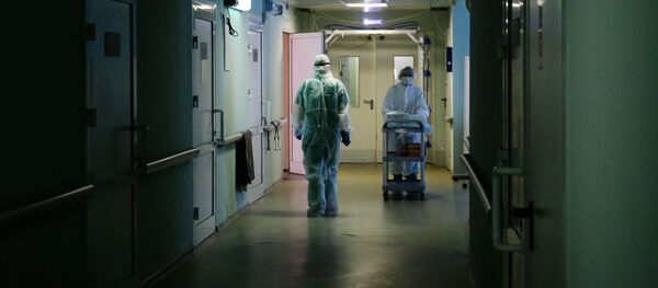 Медики в защитном противоэпидемическом костюме в коридоре Новосибирской областной клинической больницы. - 俄羅斯衛星通訊社