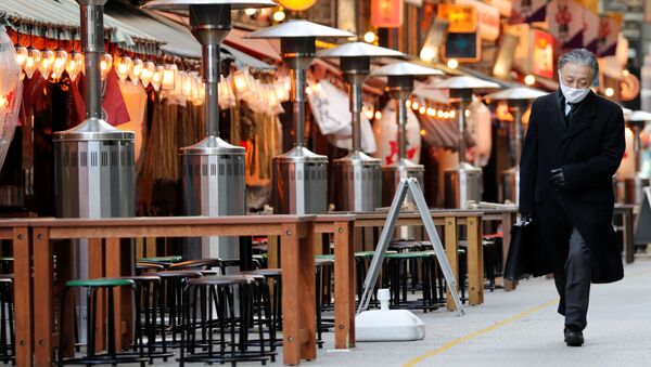 Прохожий идет мимо закрытых ресторанов в Токио - 俄罗斯卫星通讯社