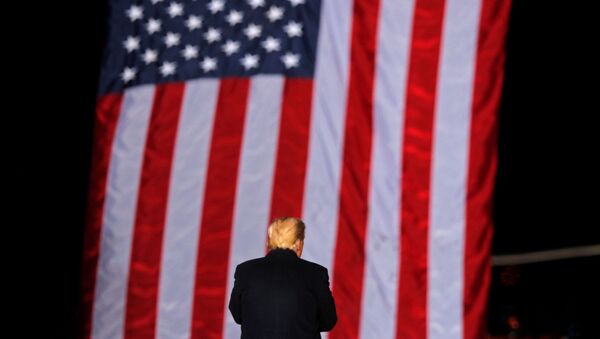 U.S. President Donald Trump stands in front of a U.S. flag while campaigning for Republican Senator Kelly Loeffler on the eve of the run-off election to decide both of Georgia's Senate seats, in Dalton, Georgia, U.S., January 4, 2021. - 俄罗斯卫星通讯社