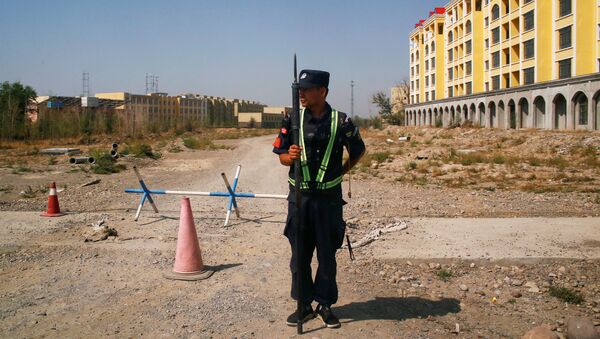 Офицер китайской полиции у центра профессионального образования в Инине в Синьцзян-Уйгурском автономном районе. - 俄羅斯衛星通訊社