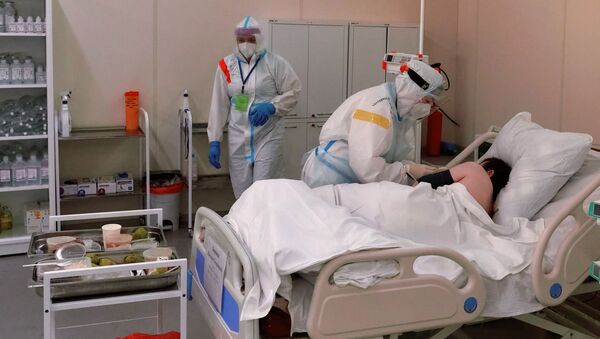 Медсестра кормит пациента в реанимационном блоке во временном госпитале для больных COVID-19, организованном в выставочном комплексе Ленэкспо. - 俄罗斯卫星通讯社