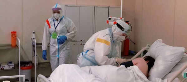 Медсестра кормит пациента в реанимационном блоке во временном госпитале для больных COVID-19, организованном в выставочном комплексе Ленэкспо. - 俄罗斯卫星通讯社