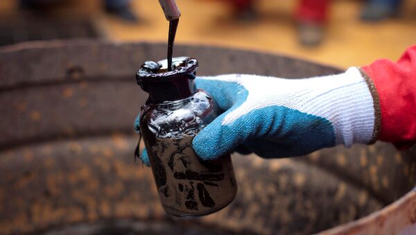 A worker collects a crude oil sample at an oil well operated by Venezuela's state oil company PDVSA in Morichal, Venezuela, July 28, 2011. - 俄罗斯卫星通讯社