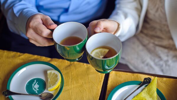 Мужчина и женщина пьют чай с лимоном - 俄罗斯卫星通讯社
