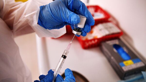 Медицинский сотрудник держит в руках вакцину Спутник-V на территории фудмолла Депо.Москва - 俄罗斯卫星通讯社