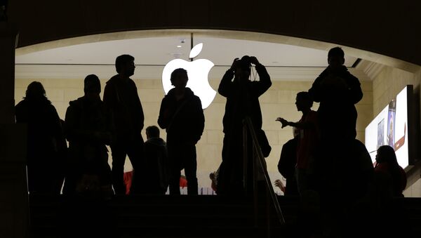Силуэты людей перед логотипом компании Apple - 俄羅斯衛星通訊社