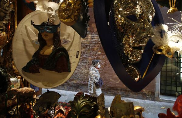 Женщина походит мимо витрины с карнавальными масками в Венеции  - 俄羅斯衛星通訊社