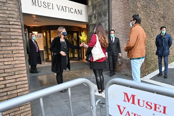 第一批遊客從梵蒂岡博物館館長芭芭拉·雅塔（Barbara Yatta）（左）手裡接過鮮花。 - 俄羅斯衛星通訊社