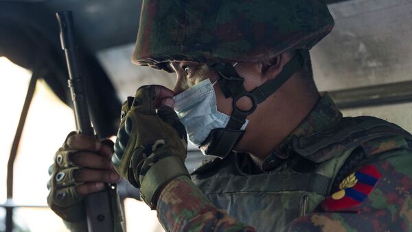 Солдат из Мьянмы поправляет маску на лице, садясь в машину перед индуистским храмом в центре города Янгон, Мьянма. - 俄羅斯衛星通訊社