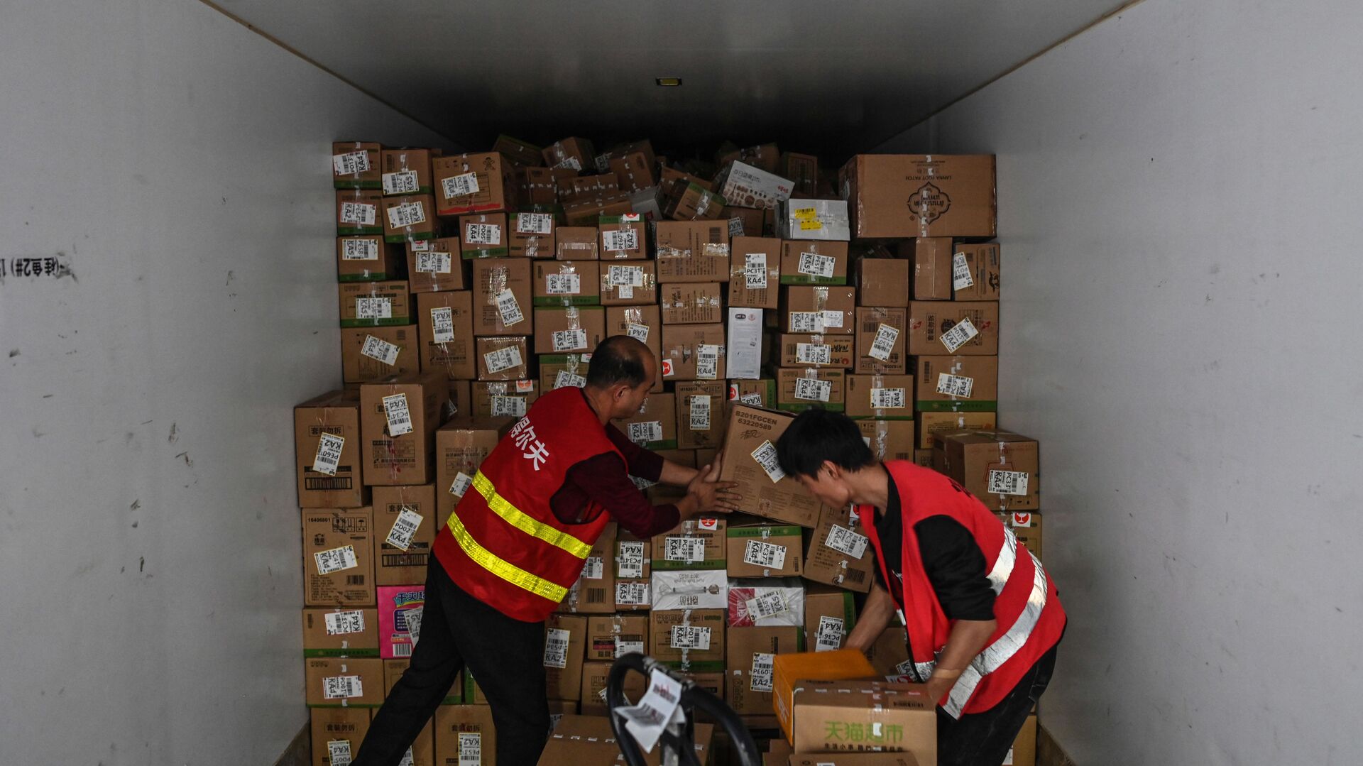 Сотрудники складывают коробки в грузовик на складе Cainiao Smart Logistics Network. Китай - 俄罗斯卫星通讯社, 1920, 25.03.2021