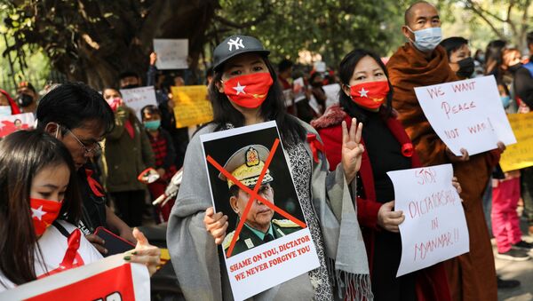 Женщина держит плакат с изображением главаря армии Мьянмы Мин Аунг Хлаинга с перечеркнутым лицом во время протеста, организованного Комитетом по делам беженцев Чина против военного переворота в Мьянме. - 俄羅斯衛星通訊社