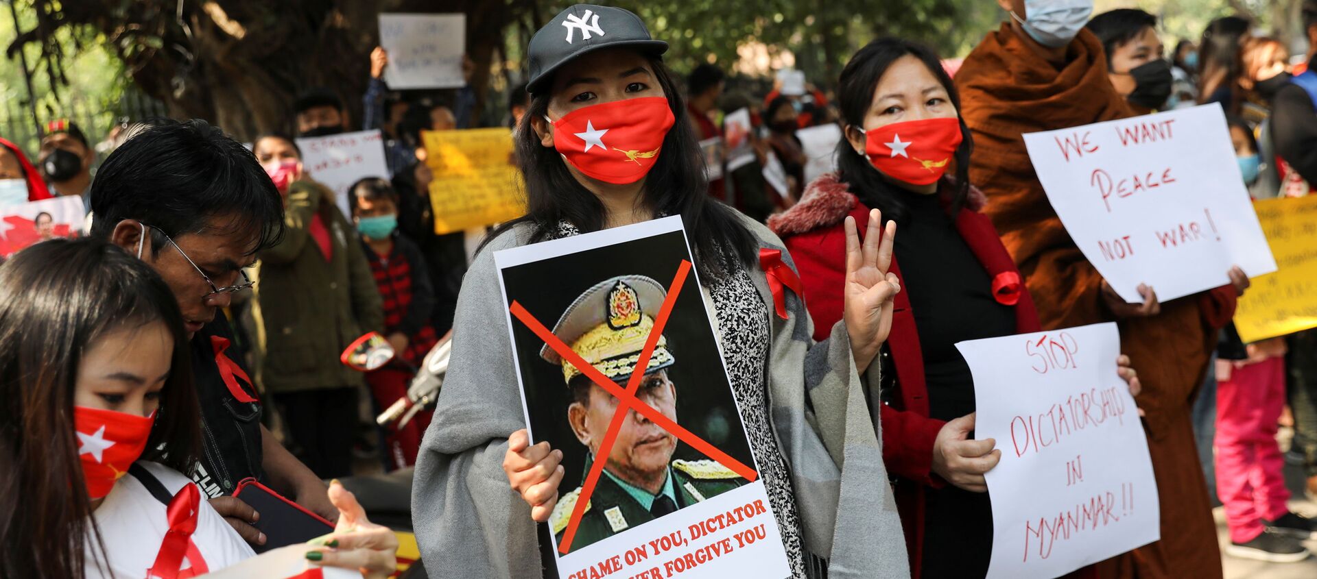 Женщина держит плакат с изображением главаря армии Мьянмы Мин Аунг Хлаинга с перечеркнутым лицом во время протеста, организованного Комитетом по делам беженцев Чина против военного переворота в Мьянме. - 俄罗斯卫星通讯社, 1920, 07.02.2021