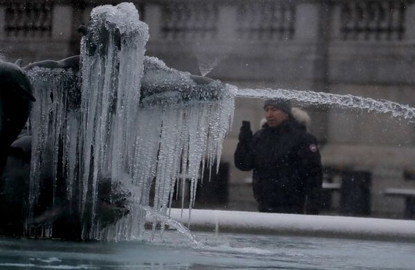 一名男子在拍摄伦敦特拉法加广场被冰封冻的雕像。 - 俄罗斯卫星通讯社